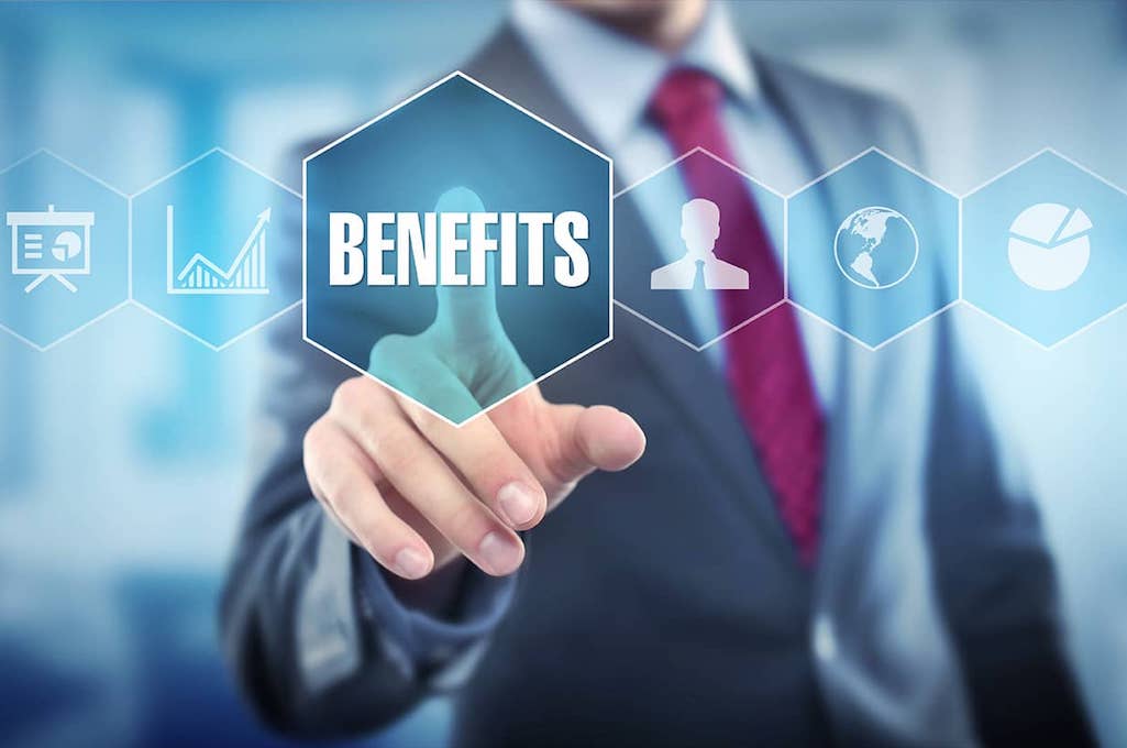A man in a suit and tie pointing to the word "benefits" that sits among a row of icons with different symbols on them.